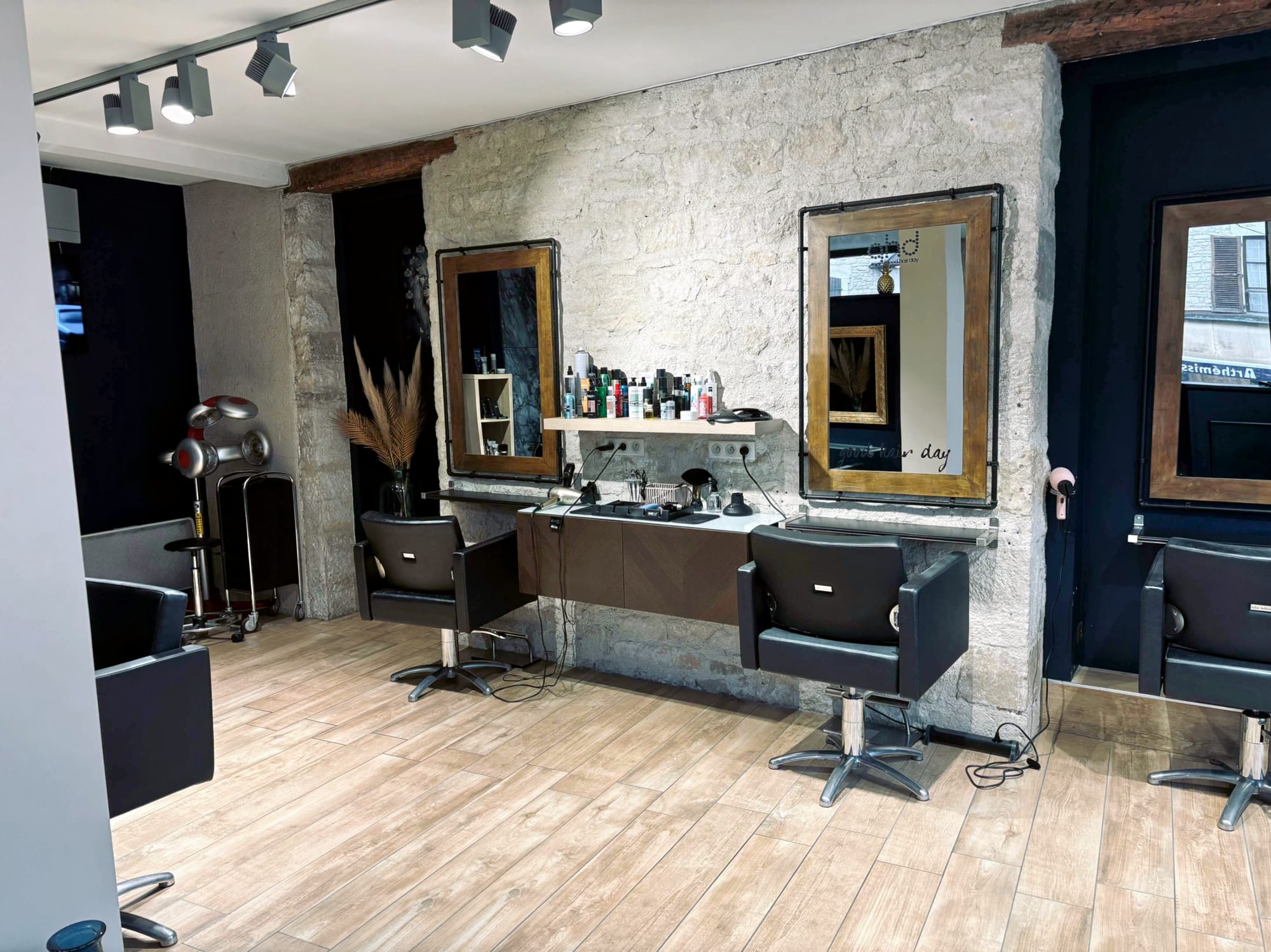 Intérieur du salon Atelier : mur en pierre et miroirs dorés